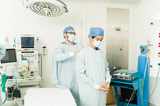 Sairaanhoitaja auttaa kirurgi laittaa kirurginen pensaikot aloittaa hätäleikkaus sairaalassa - Valokuva, kuva