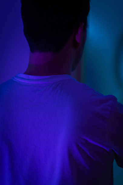 man in a blue shirt and a black t-shirts on a light background - Fotoğraf, Görsel