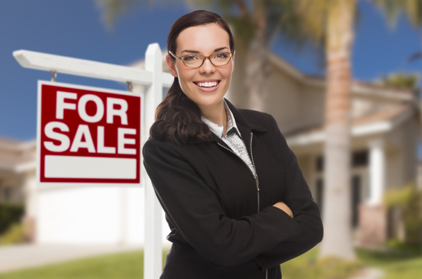 Молодая женщина перед домом и знаком продажи
 - Фото, изображение