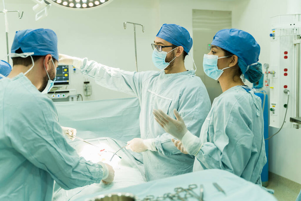 Médico quirúrgico y enfermero que realiza una cirugía a un paciente enfermo en el hospital  - Foto, Imagen