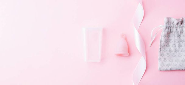 Menstrual cramp, use menstrual cup inside vagina. Pink ribbon with menstrual cup. Menstruation feminine period. Medical healthcare gynecological banner - Photo, image