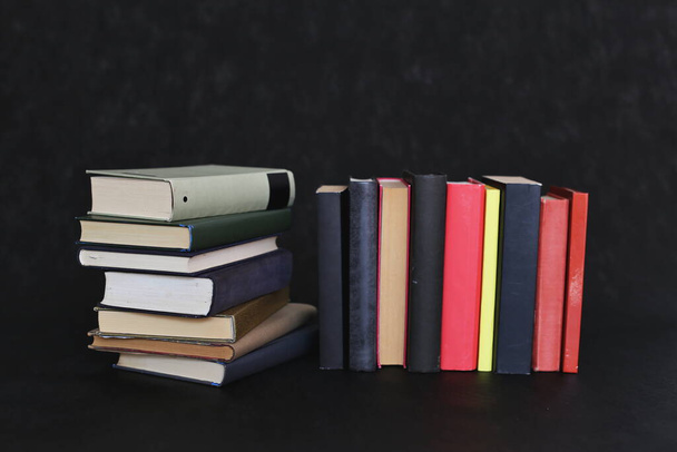 Stack of books on black background - Foto, afbeelding