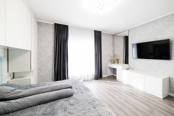 Bright, large room with bed and large window. - Foto, Bild