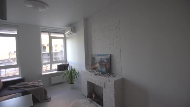 Interior del moderno loft cocina-estudio en el apartamento. Habitación, muebles, sofá cerca de la chimenea de madera - Imágenes, Vídeo