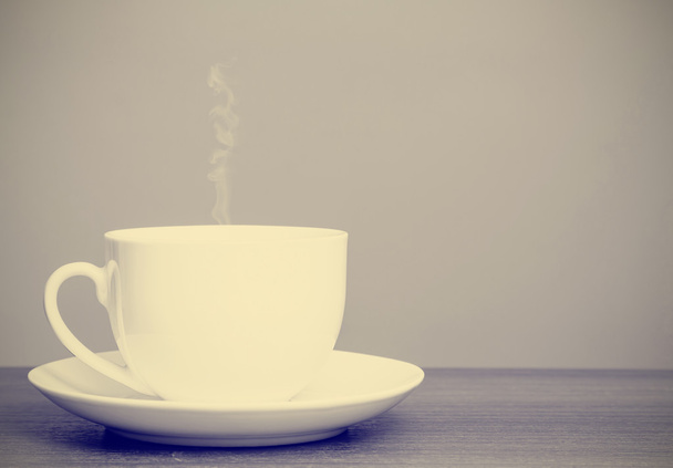 White cup and saucer on wooden table with retro filter effect - Photo, Image