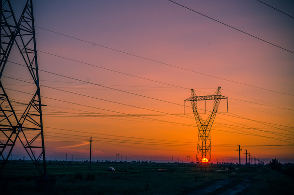 Sziluettjét villamosenergia-oszlop során naplemente - Fotó, kép