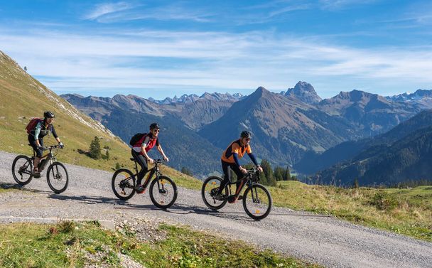 tre adulti anziani felici, in sella alle loro mountain bike nell'atmosfera autunnale delle montagne di Bregenz Wald vicino a Mellau, Vorarlberg, Austria - Foto, immagini