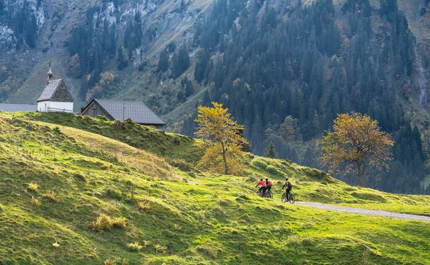 tři šťastní senioři, jezdící na horských kolech v podzimní atmosféře pohoří Bregenz Wald u Mellau, Vorarlberg, Rakousko - Fotografie, Obrázek