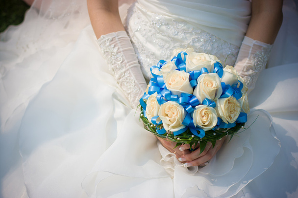 Braut im Brautkleid hält Blumen in der Hand - Foto, Bild