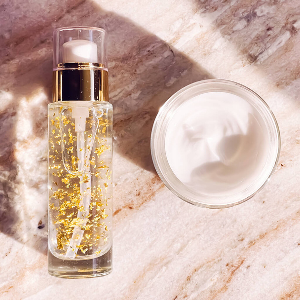 Skincare cosmetics, face cream moisturiser jar and golden serum emulsion in bottle, beauty product flatlay view - Foto, imagen