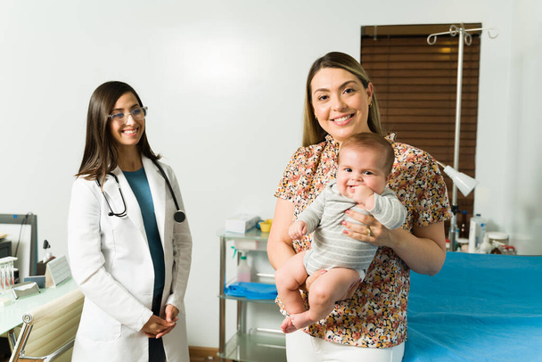 Krásná maminka přináší její rozkošné dítě pro lékařské vyšetření s ženskou pediatr  - Fotografie, Obrázek