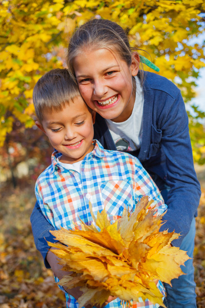 Cute kids with autumn leaves - Foto, imagen