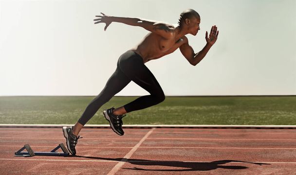 La velocidad atraviesa su espíritu. Un atleta corriendo en pista. - Foto, Imagen