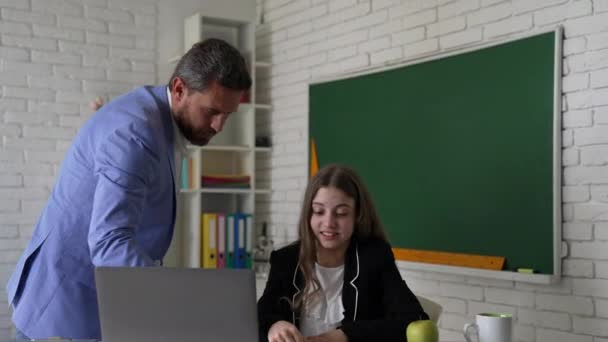enseignant en colère et fille étudier en ligne avec ordinateur portable dans la classe, expliquer - Séquence, vidéo