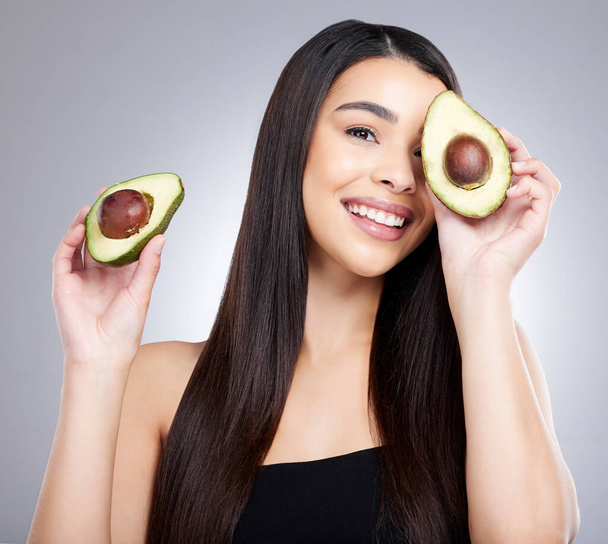 Going organic was a move in the ripe direction for me. Studio portrait of an attractive young woman posing with an avocado against a grey background. - Photo, Image