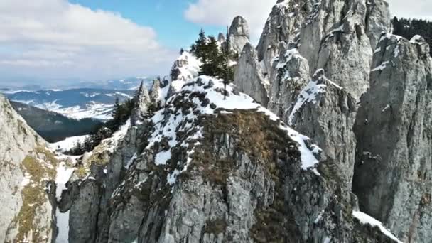 Вид с воздуха на Карпаты, Румыния. Скалистая вершина с крестом, долины частично покрыты снежным лесом - Кадры, видео