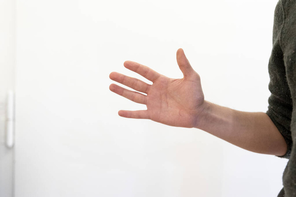 close up of a hand holding a white wall with a blurred background - Fotoğraf, Görsel