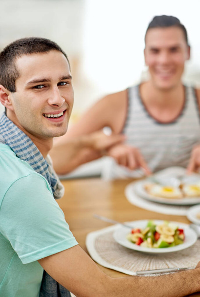 Een paar die samen eten, bij elkaar blijven. Portret van een homo koppel samen lunchen. - Foto, afbeelding