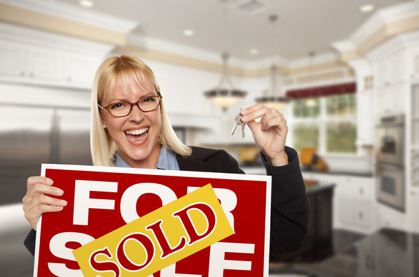 Young Woman Holding Sold Sign and Keys Inside New Kitchen - Foto, immagini