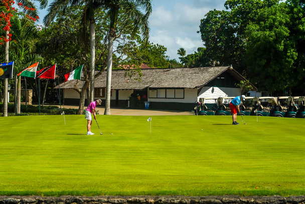LA ROMANA, DOMINICAN REPUBLIC - JUNE 10, 2021: Golfers practicing at the famous Teeth of the Dog Golf Course of Casa de Campo design by Pete Dye. Scenic 18-hole golf course, including only in the world seven seaside holes - Fotografie, Obrázek