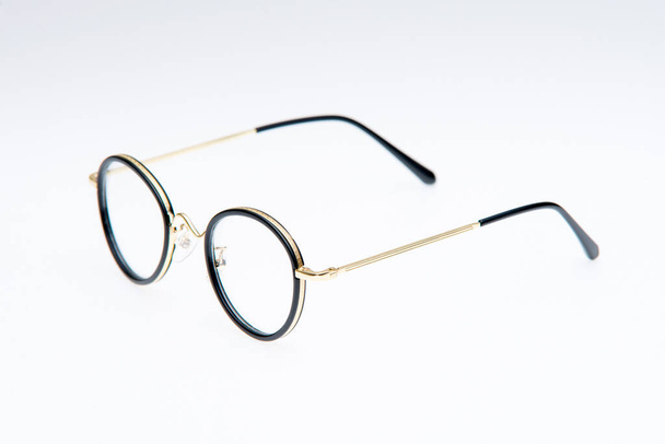 Mode-Sonnenbrille mit goldenem und schwarzem Rahmen auf weißem Hintergrund. - Foto, Bild