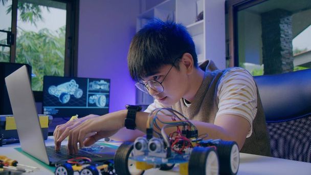 Азиатский подросток делает домашнюю работу робота Arduino в доме - Фото, изображение
