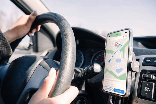 GPS-laitteen karttajärjestelmä. Maailmanlaajuinen paikannusjärjestelmä älypuhelimen näytöllä auto matkustaa tiellä. GPS-ajoneuvon navigaattorin ohjainlaite - Valokuva, kuva