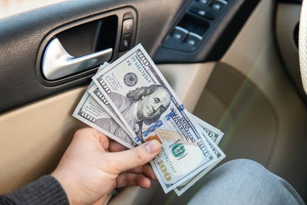 Selective focus Car key in hand and cash money in other hand of bill, Money to repair the car. Financial concept. - Photo, Image