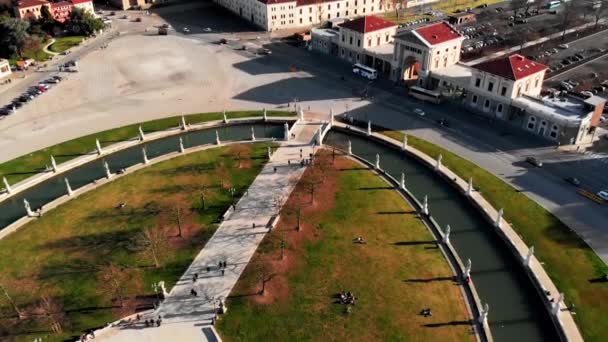 Kuzey İtalya 'daki Padua' nın hava manzarası. Prato della Valle 'nin insansız hava aracı görüntüsü. Meydanın merkezi etrafında elips şeklinde bir kanal var. Kanal üzerinde köprüler ve çift sıra heykeller. - Video, Çekim