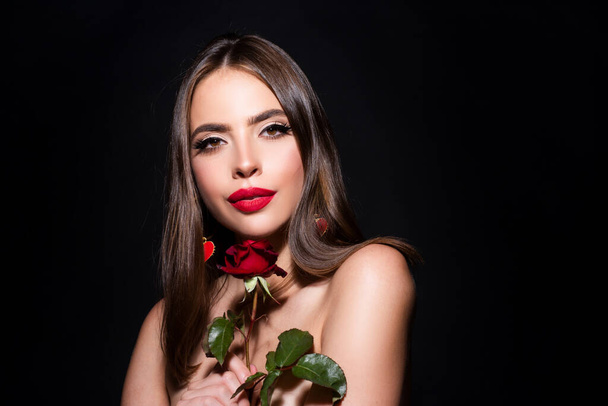 Beautiful woman with naked shoulder and rose. Brunette girl with flower. Closeup face of young beautiful woman with a healthy clean skin. Pretty woman with bright makeup. - Fotografie, Obrázek