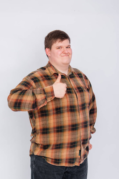 Fat guy showing thumb up isolated on white background. Young man making a gesture, I like it, great job. Body language, body positivity. - Photo, image