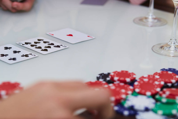 Pokerspiel mit Chips, Karten auf dem Tisch. Den Moment genießen, mit Freunden digital entgiften. Lifestyle-Fotografie. Ehrlicher Moment. Selektiver Fokus - Foto, Bild