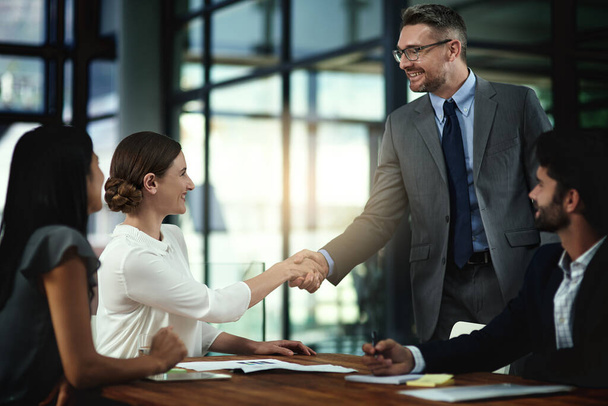 Its a pleasure to finally meet you. Shot of two businesspeople shaking hands during a meeting in the boardroom. - Фото, изображение