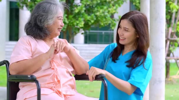 Asijské pečovatel nebo zdravotní sestra pečující o pacienta na invalidním vozíku. Koncept šťastného odchodu do důchodu s péčí pečovatele a spořitelen a seniorského zdravotního pojištění, šťastná rodina - Záběry, video