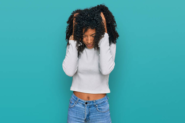 Young african american girl wearing casual clothes suffering from headache desperate and stressed because pain and migraine. hands on head.  - Fotoğraf, Görsel