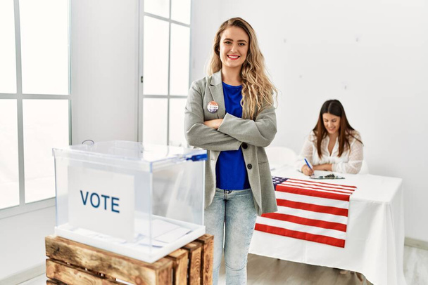 若いアメリカの有権者の女性は私が投票したバッジスタンドで両腕を組んでジェスチャーを渡った. - 写真・画像