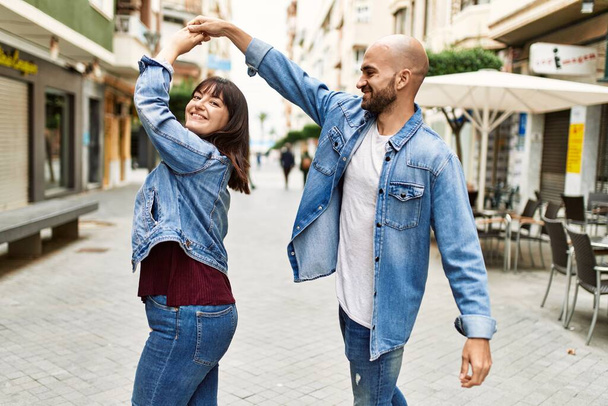 Genç İspanyol çift gülümsüyor, şehirde mutlu dans ediyorlar.. - Fotoğraf, Görsel