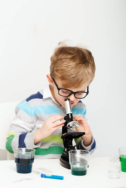 Çocuk beş yaşında, renkli sıvılarla deney yapıyor. Avrupa görünümlü küçük bir bilim adamının kimyasal deneyleri.. - Fotoğraf, Görsel