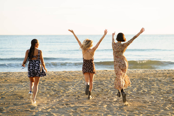 Απεριόριστες φίλες περπατούν προς τη θάλασσα - Φωτογραφία, εικόνα