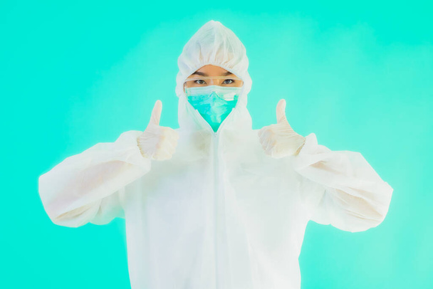 Retrato hermosa joven asiática médico mujer usar ppe o equipo de protección personal para proteger de coronavirus o covid19 sobre fondo aislado azul
 - Foto, imagen
