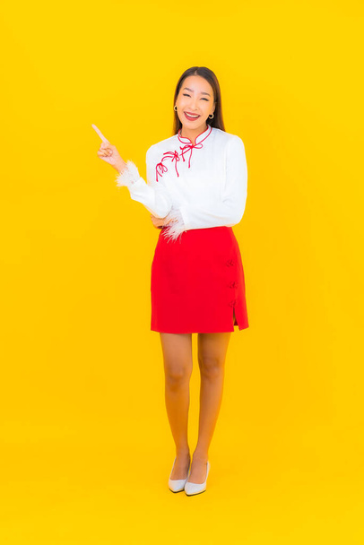Portrait beautiful young asian woman smile in action on yellow background - Zdjęcie, obraz