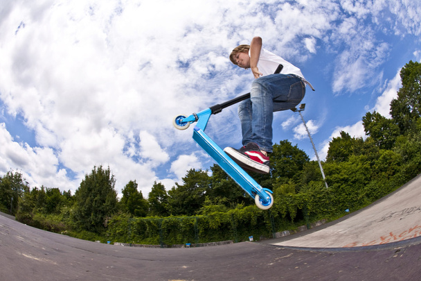 Junge mit Roller fliegt in die Luft - Foto, Bild