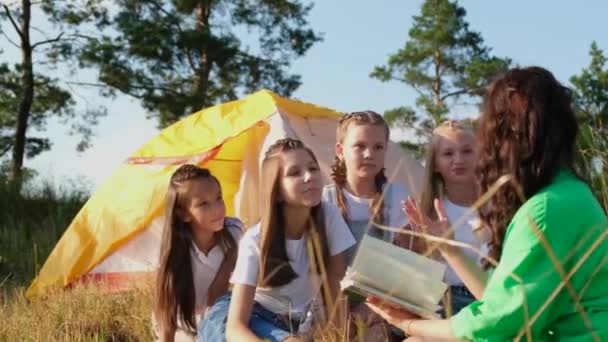 ある若い教師が教育者の仕事を通してサマーキャンプの女の子に本を読む. - 映像、動画