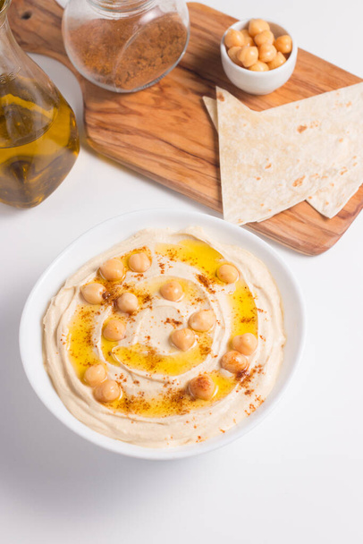 Hummus in a plate with chickpeas, smoked paprika, olive oil and  - Fotoğraf, Görsel