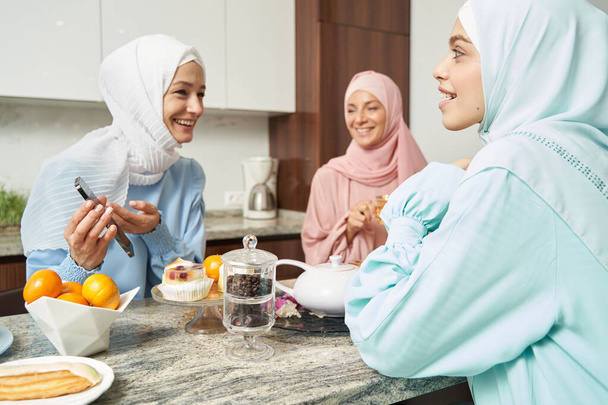 Ενθουσιασμένες Μουσουλμάνες να γελάνε στην κουζίνα - Φωτογραφία, εικόνα