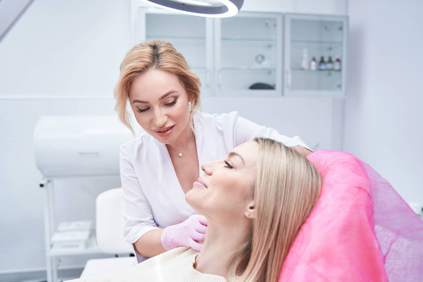Concentrated aesthetic clinic doctor conducting mesotherapy procedure - Valokuva, kuva