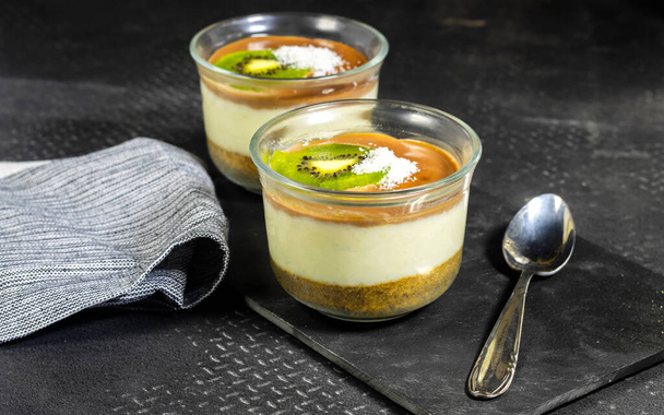 homemade vanilla and chocolate with butter cookies and nuts  pudding decorated with kiwi fruit and coconut  - 写真・画像