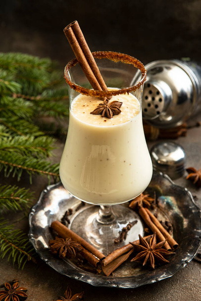Homemade eggnog with cinnamon on dark table. Traditional Christmas dessert - Фото, зображення