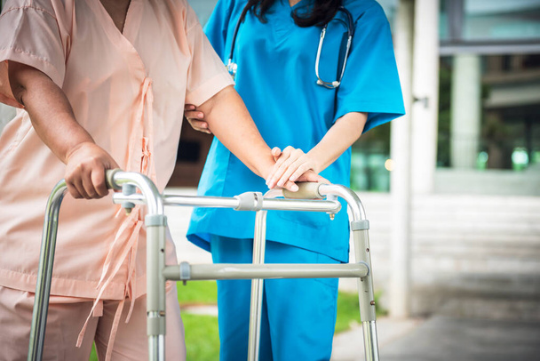 The doctor holding hands, encouraged and supported the patient, Which holds a cane to help support in the hospital, to  health insurance and osteoarthritis concept. - Photo, Image