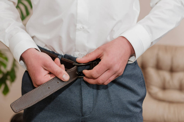 Groom holding hands on belt - Фото, изображение